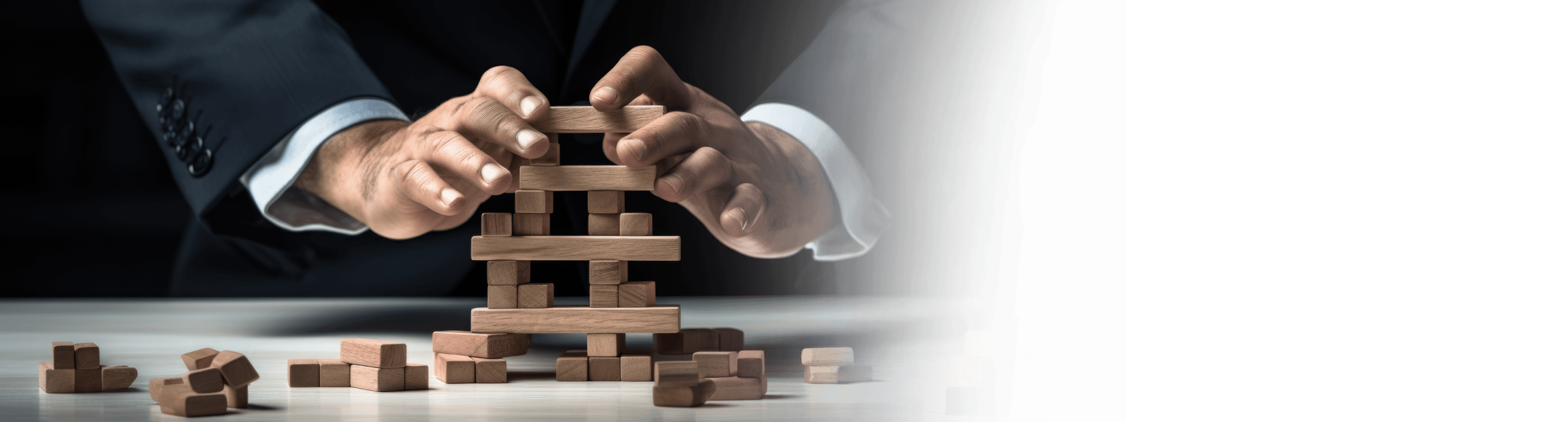 Hands carefully balancing a stack of wooden blocks